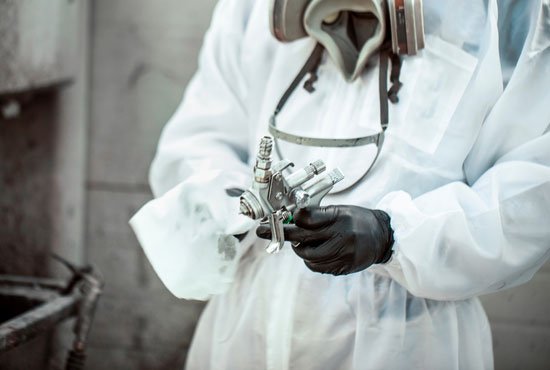Car painter cleaning his spray gun